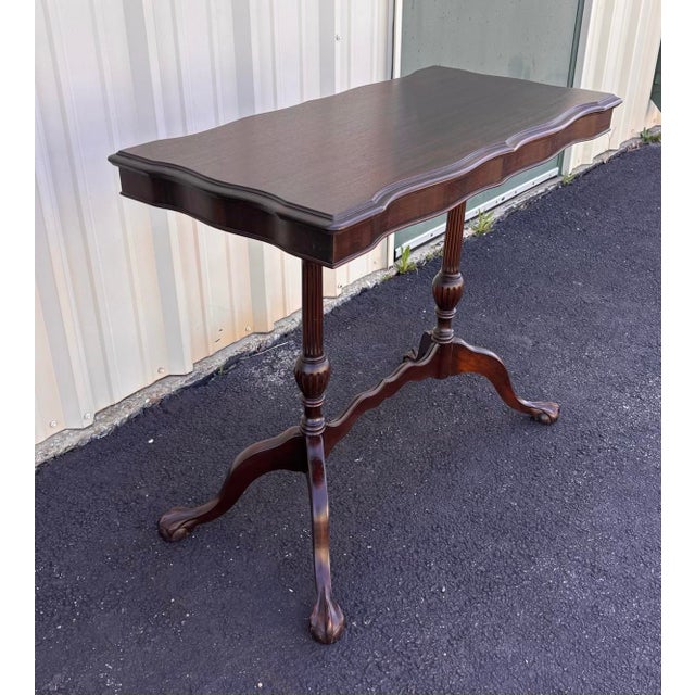 A stunning scalloped edge rectangular console or side table from the early 1900s. This side table is made entirely of dark...