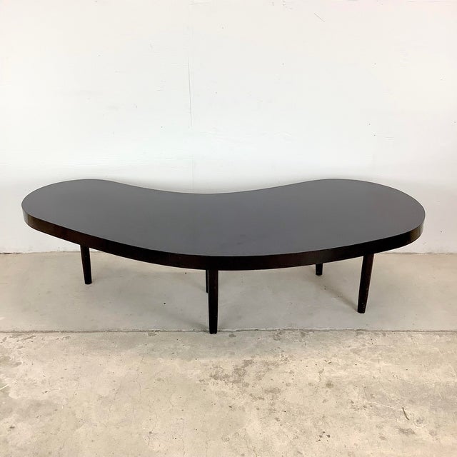 This vintage coffee table is a bold expression of Atomic Modern design, defined by its sculptural kidney-shaped silhouette...