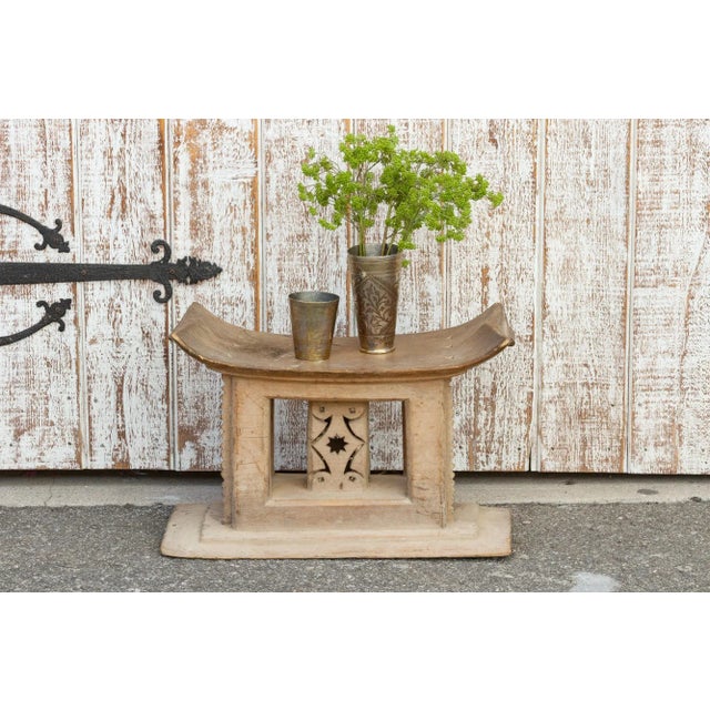 An authentic Ashanti stool, carved from a single piece of wood. With a concave top, a central column rises from a shaped...