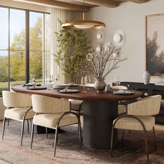 The Marlow Oval Dining Table exudes sophistication with its deep brown wood top and sleek black base. The rich, dark...
