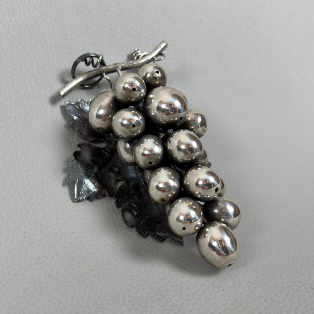 This refined sculpture captures the essence of nature through a meticulous depiction of a bunch of grapes, where the...