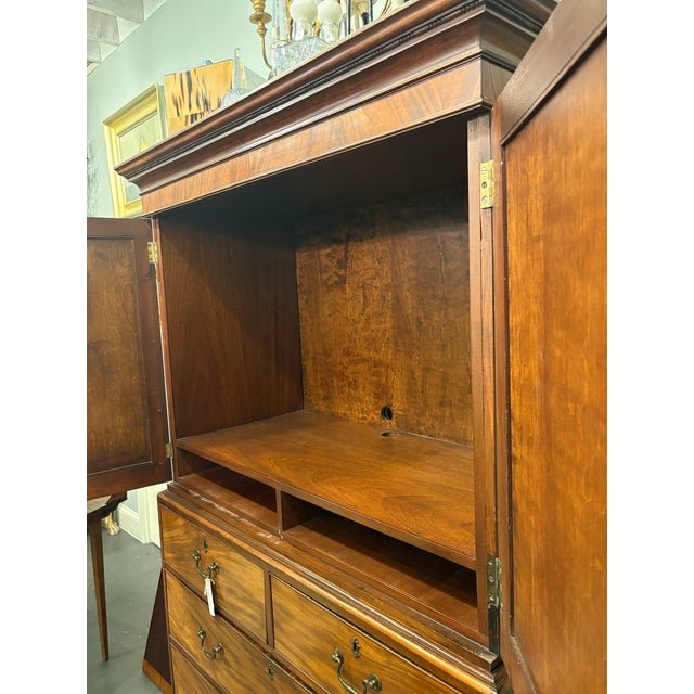 This is an antique linen press circa 19th century. This is a two piece English design. It has an upper cabinet with a lock...