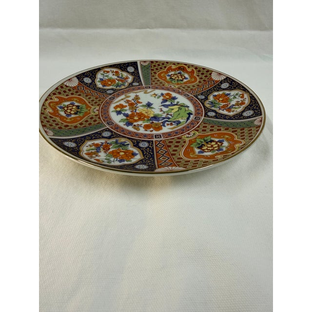 A vintage Japanese Imari porcelain plate hand-painted in the traditional palette of blue, red, and gold. Smaller at 8 1/4...