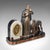 This is a large vintage figural mantle clock. A French, onyx and spelter timepiece with matched garnitures, dating to the...
