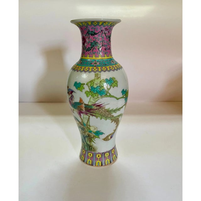 An interesting vase featuring a pair of birds in a tree as a main theme and bordered at the top with a floral pattern and...