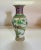 An interesting vase featuring a pair of birds in a tree as a main theme and bordered at the top with a floral pattern and...
