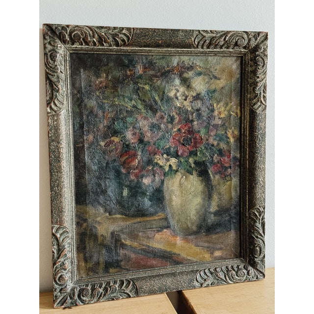 This exquisite Belgian oil painting from 1920 depicts a vibrant still life of mixed flowers arranged in a cream-colored...
