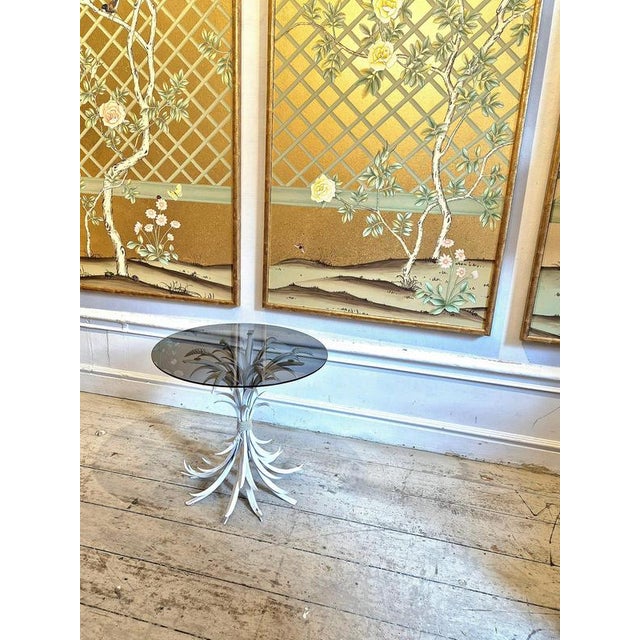 A rare side table in wheatsheaf shaped white lacquered metal and glass top. by Hans Kögl 1960/70s. Coco Chanel had the...