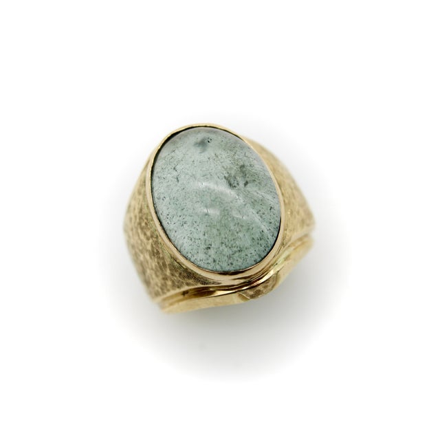 This vintage handmade ring features a large oval prehnite cabochon bezel set in a wide 14k gold band. The band has a...