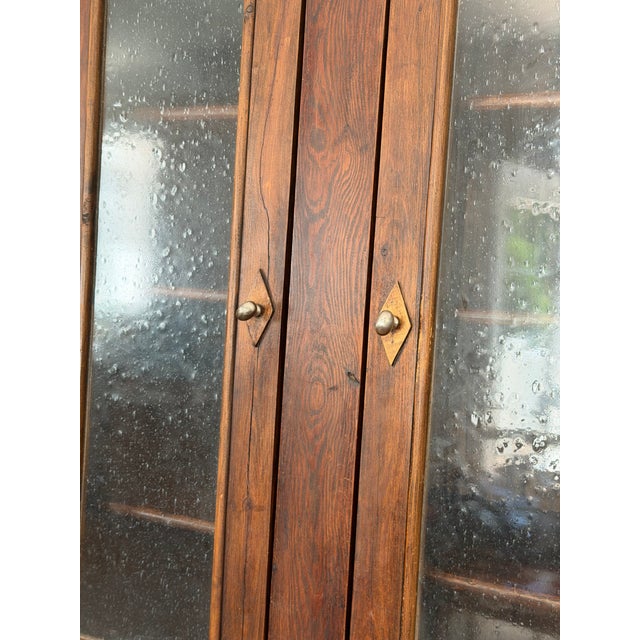 A handsome two-piece step-back hutch in dark-stained pine with rich wood grain throughout. The upper section features two...