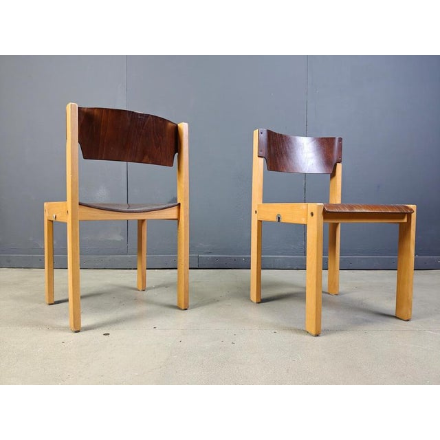 Sven Markelius style two-toned stacking chairs with simple modernist birch frames and brown seats and backs. The chairs...