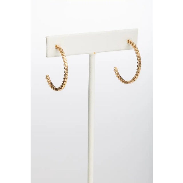 Pair of unusual 18K gold hoops with a textured design. Diameter is 1 inch. Gold post with push for pierced ears. The fine...