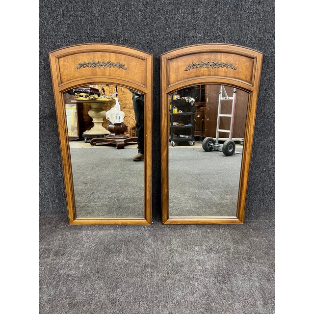 Traditional pair of Walnut mirrors by Drexel Furniture Co with leaf/vine accents.