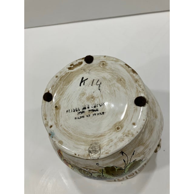 This hand painted pottery cachepot is marked made in Italy The floral designs are on both sides Nice applied handles