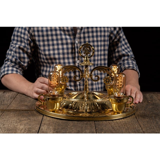 A finely detailed brass flush mount fixture with four lights radiating from a domed base. The design incorporates floral...