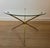This round tripod coffee table with a pleasing design is made of brass with a glass top. It is a French work. Circa 1970