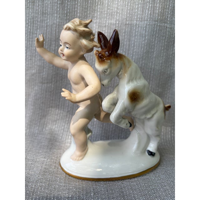 Vintage porcelain figurine of a young child and his goat playing. Made in Germany by Wallendorf, makers mark is on the...
