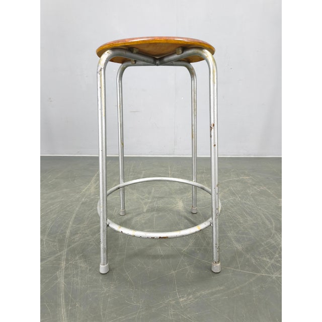 Mid-century industrial stool produced in Germany during the 1950s. This piece features a sturdy lacquered metal frame...
