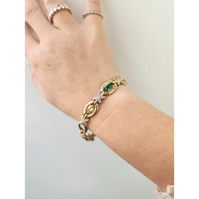 We offer free 2-day shipping! This is a lovely vintage 14K gold bracelet featuring vivid emeralds, imperial topaz &...