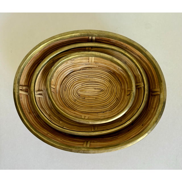 Here is a fantastic collection of rattan/pencil reed woven bowls with a brass trim attributed to the famed designer,...