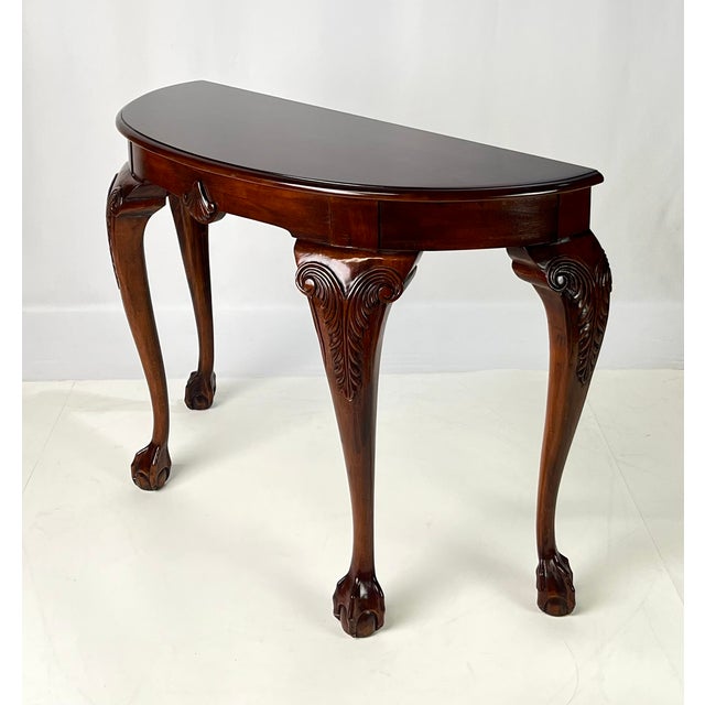An elegant Queen Anne / Chippendale style demilune console table crafted from warm cherry wood. This half-round wall table...