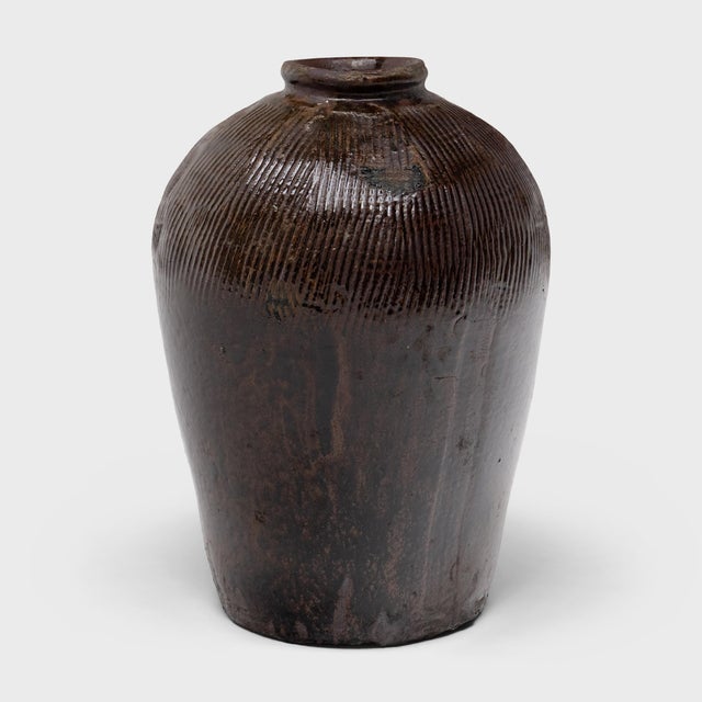 This large ceramic jar is a vintage Chinese wine vessel from the early 20th century, originally used for aging wine and...