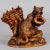 A whimsical swiss wood carving. A long hair terrier is begging with his masters hat beside a basket. Handcarved ca. 1900...