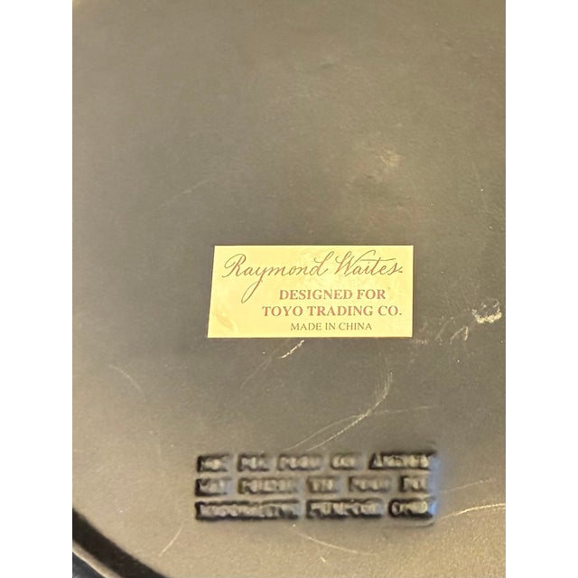 A pair of Raymond Waites decorative pottery plates printed with a design of a man and a woman in historic costume,...