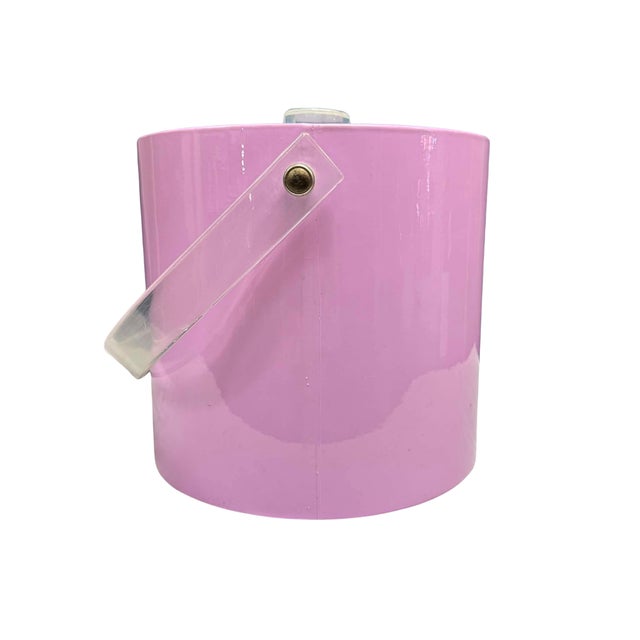 A playful vintage “Mr. Ice Bucket” featuring a glossy pink cylindrical body, clear Lucite swing handle, and fitted...