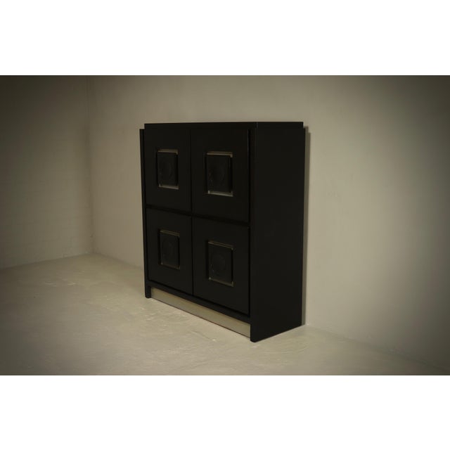 Brutalist cabinet made in Belgium in the 1970s. The cabinet is characterized by its bold geometric door panels and strong...