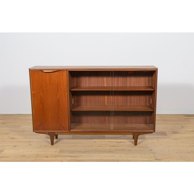 This Mid-Century bookcase in rosewood was produced in Great Britain by Mcintosh in the 1960s. The bookcase has profiled...