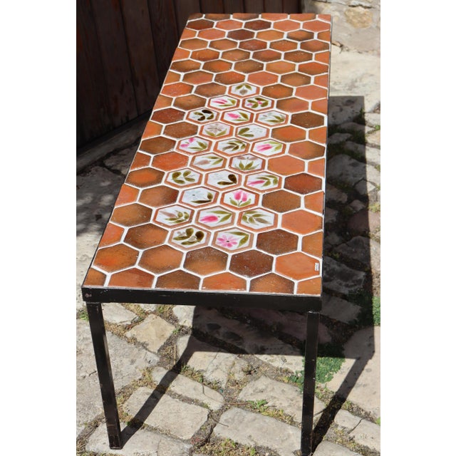 Coffee table in ceramic and Provençal terracotta tiles. Colorful floral ceramic decoration. Black metal base and frame....