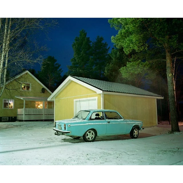 "Volvo Sky" is a dynamic C-Type print by Samuel Hicks. A turquoise pastel Volvo car sits quietly in the driveway of a...