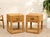 A charming pair of vintage rattan nightstands with woven surfaces, single drawers, and open lower shelves. Each table is...