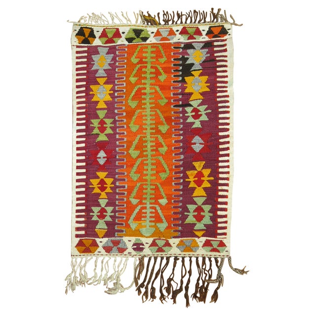 A scatter Turkish Kilim from the mid-20th century highlighted in purple & orange shades Measures: 2'4'' x 3'7".