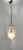Medium-sized suspended murano glass lantern, elegantly decorated with a curled golden brass structure that envelops a...