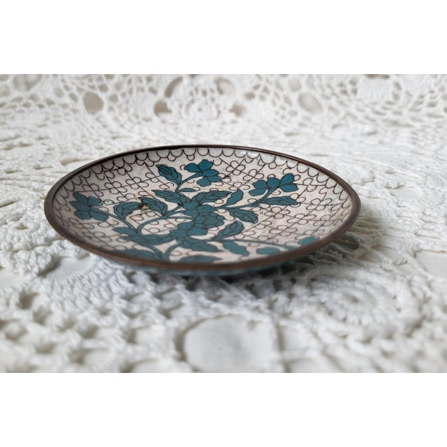 A small turquoise and white floral cloisonne dish. Perfect to hold rings or used as a spoon rest. There are some chips on...