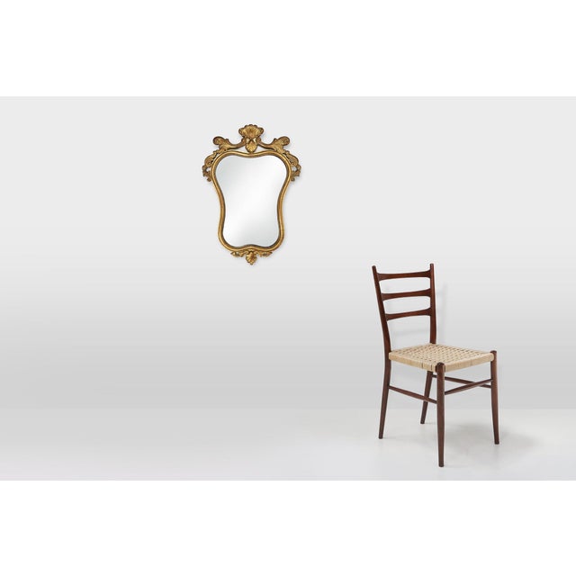 This mid‑century Belgian mirror from around 1950 is crafted in wood and shaped in a richly decorative Baroque‑Rococo...