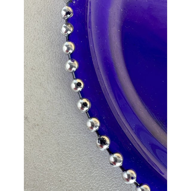 Cobalt blue glass plate. Plate is 12” in diameter with painted silver beaded edge. Use as a center decorative plate or...