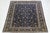 This Kashan Persian wool rug has a navy blue field with an allover floral pattern in yellow, beige, and light blue hues....
