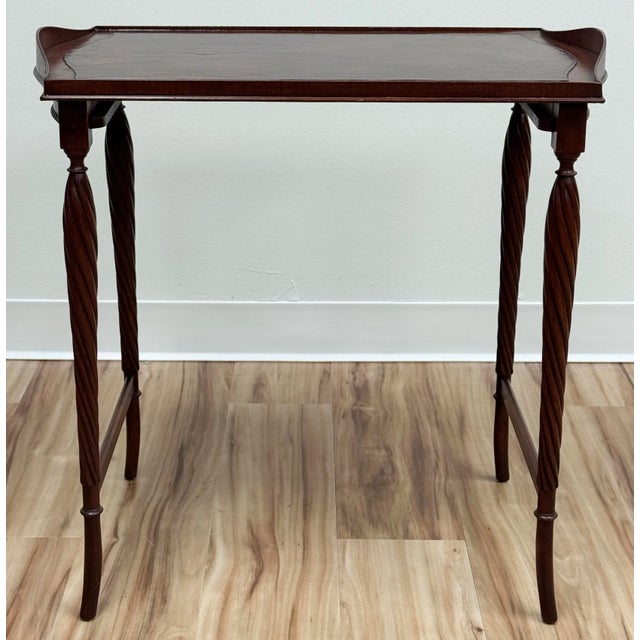Antique Mahogany wood tea table featuring embellished leather top and four curved carved wood legs supported by two...