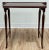Antique Mahogany wood tea table featuring embellished leather top and four curved carved wood legs supported by two...