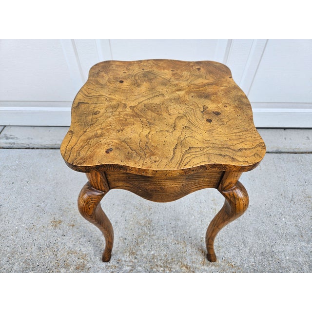 A gorgeous square and somewhat diminutive side table with a burlwood top by Baker Furniture. A versatile piece at 14.5...