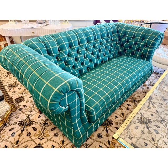 Tailored Chesterfield loveseat upholstered in a deep emerald-green wool flannel with an oversized ivory and muted-gold...