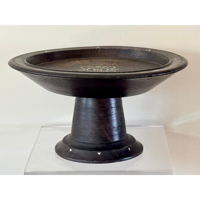 A footed wooden tray with mother of pearl inlay. Used in Balinese ceremonies. A good example in a deep rich patina.