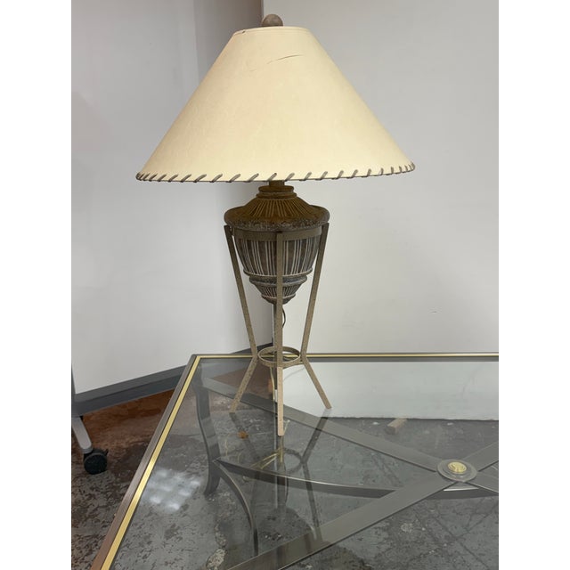 Design Plus Gallery presents a Rustic Patinated Metal Tripod Table Lamp + Laced Shade. This table lamp has a speckled...