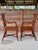 A striking pair of British Colonial style tortoise rattan side arm chairs featuring beautifully sculpted arms, rich...