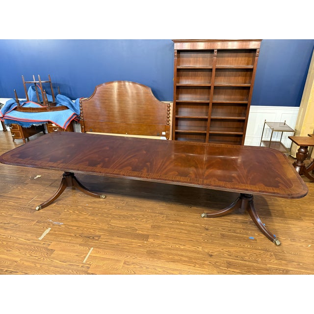 This is a Traditional Multi-Banded Mahogany Dining Table by Leighton Hall Furniture. It features a field of swirly crotch...