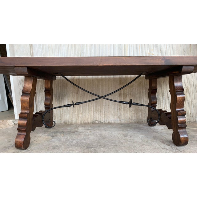 A monumental 20th century Spanish trestle table, having a rectangular framed solid walnut inset board top, resting on hand...