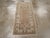 A vintage Turkish Oushak throw rug. This narrow rustic scatter has a medium brown field with a sparse decoration of a...